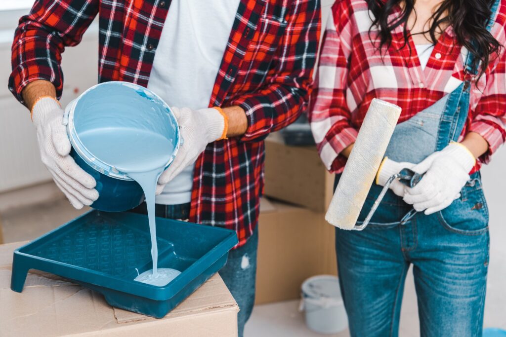 Man Tinting Primer By Pouring Blue Paint From Bucket Resized