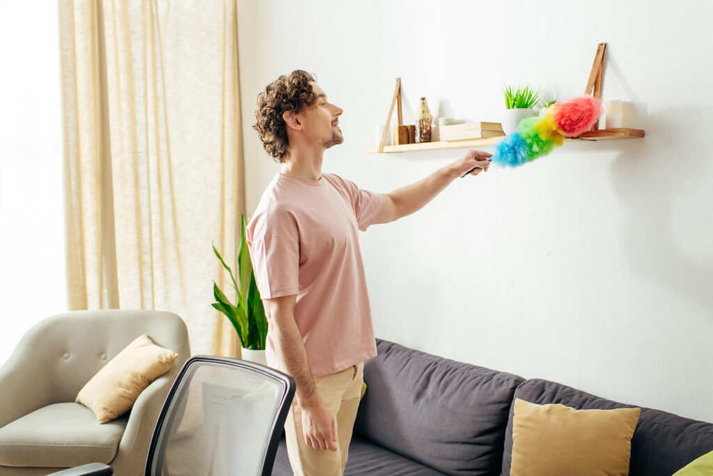 Man With Duster Cleaning Wall Before Painting